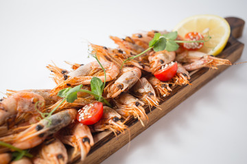 Lots of shrimps on the wooden board with lemon