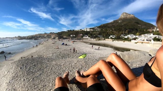 Woman sits on Cape Town beach, POV