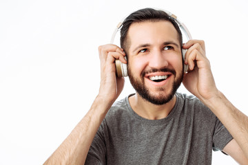 Fototapeta premium Happy hipster man, smiling while listening to music on headphones. on white background.
