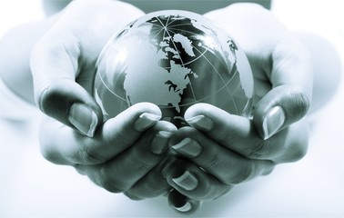 Female hands holding glass Globe on background