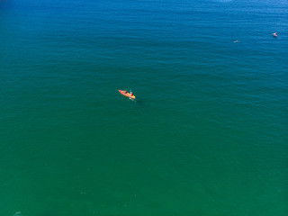 Fototapeta premium The aerial view of unrecognizable people rises paddle boarding on the surface of the water for sport, and fun. Enjoy the summer SUP activity for holidays.