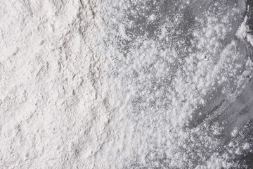 Baking flour spread out and sprinkled on metal cookie sheet