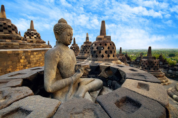 View of meditating Buddha statue and stone stupas in borobudur. Great religious architecture. Magelang, Central Java, Indonesia - obrazy, fototapety, plakaty