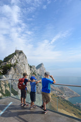 Children on vacation looking for adventure and out over a panoramic view of mountains, beach, sea.