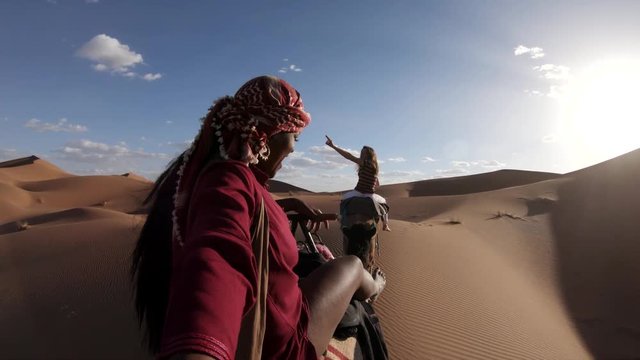 POV, riding camel over sand dunes