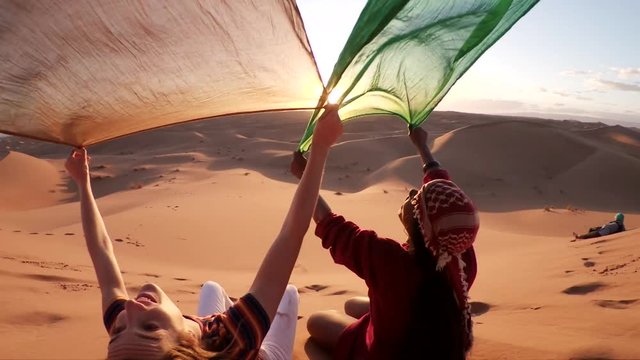 Colorful cloth blows in breeze during desert sunset, slow motion