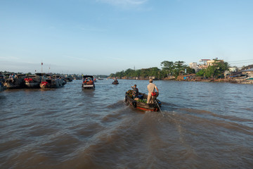 Obraz premium Traffic and transport on floating market by vessel, boat, ship in Cai Rang floating market at Mekong River. Royalty free stock image of the floating market or river market in Can Tho, Vietnam