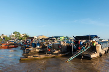 Fototapeta na wymiar Tourists, people buy and sell food, vegetable, fruits on vessel, boat, ship in Cai Rang floating market, Mekong River. Royalty stock image of traffic on the floating market or river market in Vienam