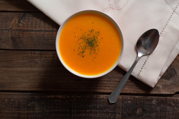 crema de calabaza en tabla de madera con mantel y cuchara