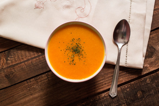 crema de calabaza para el oto&ntilde;o con cuchar&oacute;n y mesa de madera
