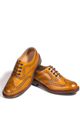 Male Footwear. A Pair of Full Broggued Tan Leather Oxfords Shoes. Placed on One Another. Isolated Over White Background.