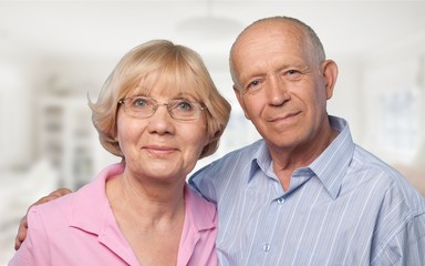 Portrait of happy senior couple smiling in blurred garden