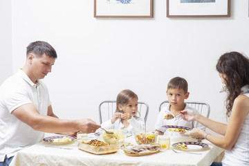 Obraz na płótnie Canvas Family Concepts and Ideas of Combined Eating. Happy Parents with Their Children Having Breakfast at Home Together