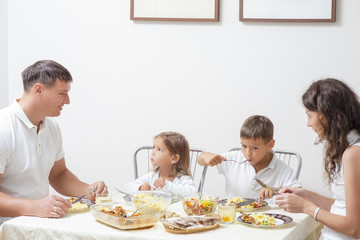 Obraz na płótnie Canvas Family Concepts and Ideas of Combined Eating. Happy Parents with Their Children Having Breakfast at Home Together.
