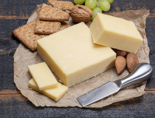 Block of aged cheddar cheese, the most popular type of cheese in United Kingdom and USA, natural cheese made from cow milk