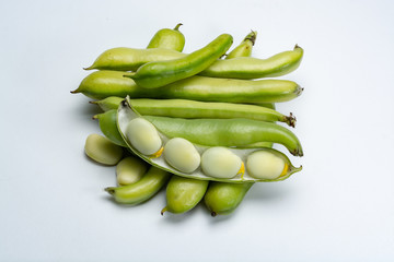 New harvest of healthy vegetables, green fresh raw big broad beans close up isolated on white background