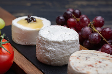 French soft cheeses, variety of different taste goat milk natural cheeses on granite plate close up sesrved as dessert