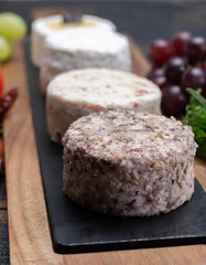 French soft cheeses, variety of different taste goat milk natural cheeses on granite plate close up sesrved as dessert