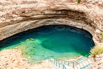Bimmah Sinkhole in eastern Muscat Governorate, Oman. It is 50 m by 70 m wide and approximately 20 m deep. - obrazy, fototapety, plakaty
