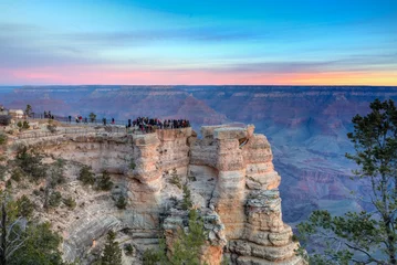 Fotobehang Dawn Arrives at the South Rim, Grand Canyon, Pink Glow in the Sky and Tourists at the Vista Point © Jill Clardy
