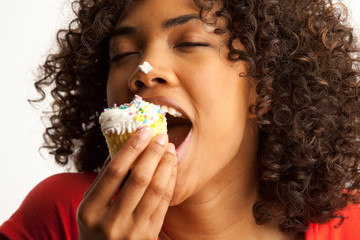 Portrait of young woman enjoying sweet cupcake