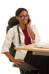 Close view of millennial female doctor talking on cellphone sitting at desk