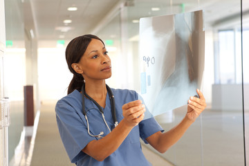 Young professional African-American doctor examining x-ray of patients chest