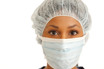 Close up of female surgeon wearing mask and hair net on white backdrop