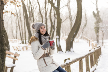 Fototapeta na wymiar Girl drinking tea in the snow