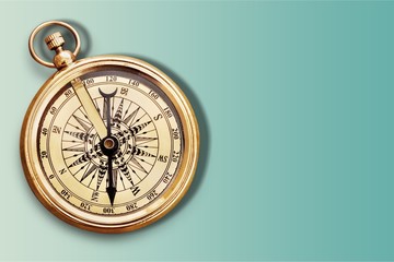 Brass antique compass on wooden background
