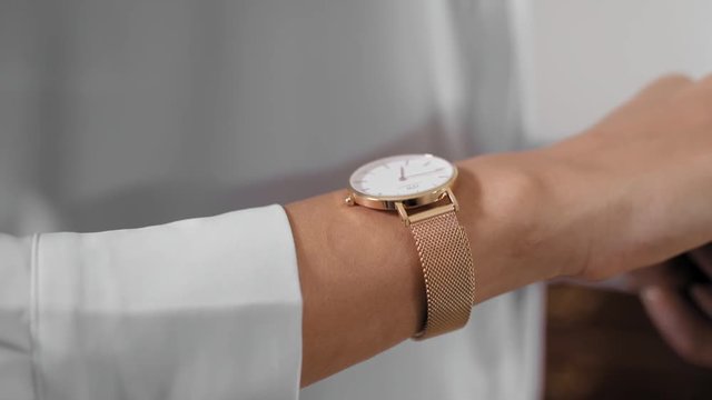 Gold watch in a women wrist. Gold watch in a women wrist, hand, looking at clock, preparing for an event. 4k footage