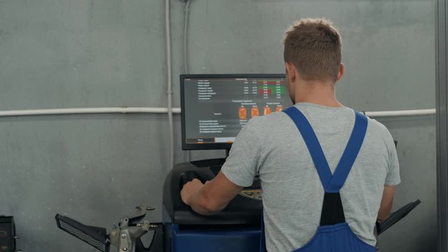 Professional mechanic adjusting automobile wheel alignment car service repair