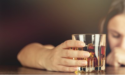 Young beautiful woman in depression, is drinking