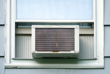 old air conditioner installed on house window