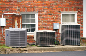  old air conditioner compressors outside the apartment building