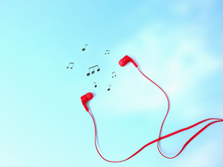 Red earphones and music note symbol on sky blue background with copy space.