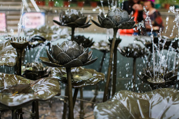 Close up fountain with bronze lotus flowers and leaves in park of the temple in hong kong