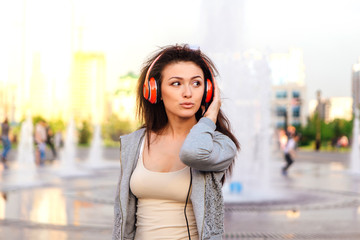 Young woman listening to music streaming with headphones.