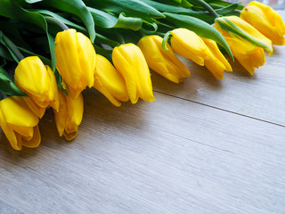 Fresh yellow tulips on wooden background tulips