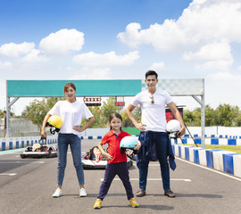 happy family standing on the go kart race track - obrazy, fototapety, plakaty