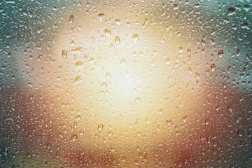 Fototapeta na wymiar raindrops on glass window with sun light effect close up rain drop for background
