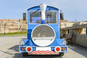 Touristic mini train on wheels in the city of Nessebar, Bulgaria.front view of a electric locomotive.