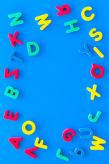 Alphabet for kids concept. English letters in disorder on blue background top view copy space