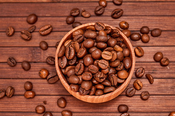 Coffee composition on a wooden background. Grains of coffee in a wooden jar. Lattice coffee beans close-up on a wooden surface. Coffee beans.
