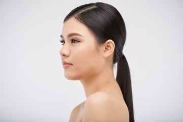 Attractive young Vietnamese woman, isolated on light grey