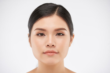 Obraz premium Face of attractive young Asian woman with natural make-up looking at camera