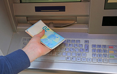 Boy takes money at ATM