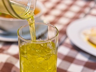 Trying to pour chrysanthemum tea drink into a glass, in restaurant background