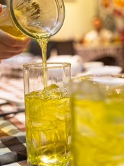 Trying to pour chrysanthemum tea drink into a glass, in restaurant background