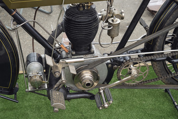 Image of the engine and pedals of an old motorcycle.